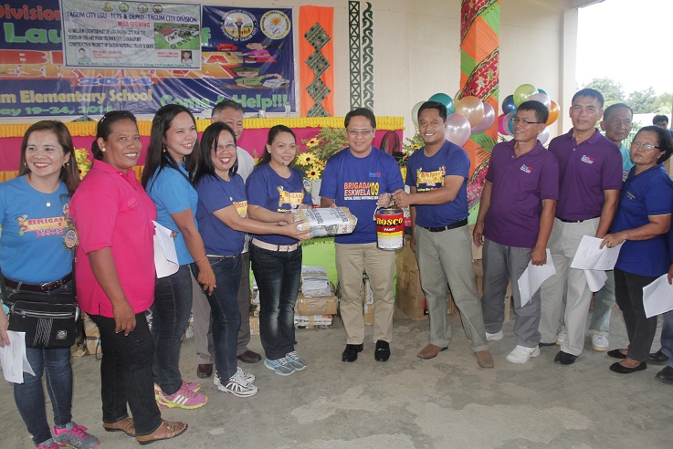 In this ceremonial turn-over, Mayor Allan L. Rellon gives paints and class records to the school principals during the division launching of the Brigada Eskwela in Madaum Elementary School in Tagum City last May 19, 2014. Photo by Leo Timogan of CIO Tagum